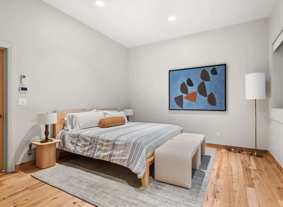 This stunning bedroom boasts a modern design with a touch of warmth.