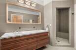 This modern bathroom boasts a sleek design with a double vanity and a walk-in shower.