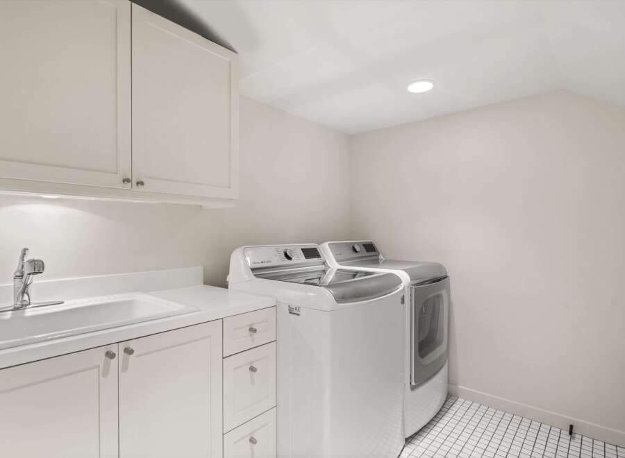 This bright and airy laundry room features a modern design with ample storage and functionality.