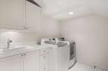 This bright and airy laundry room features a modern design with ample storage and functionality.