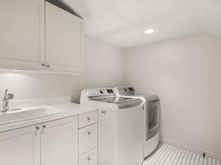 This bright and airy laundry room features a modern design with ample storage and functionality.