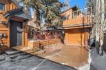 This stunning property boasts a modern design with beautiful wooden siding and a sleek, dark-colored door.