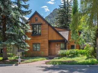 Experience modern mountain living in this stunning wood-clad home, nestled against a backdrop of majestic peaks.