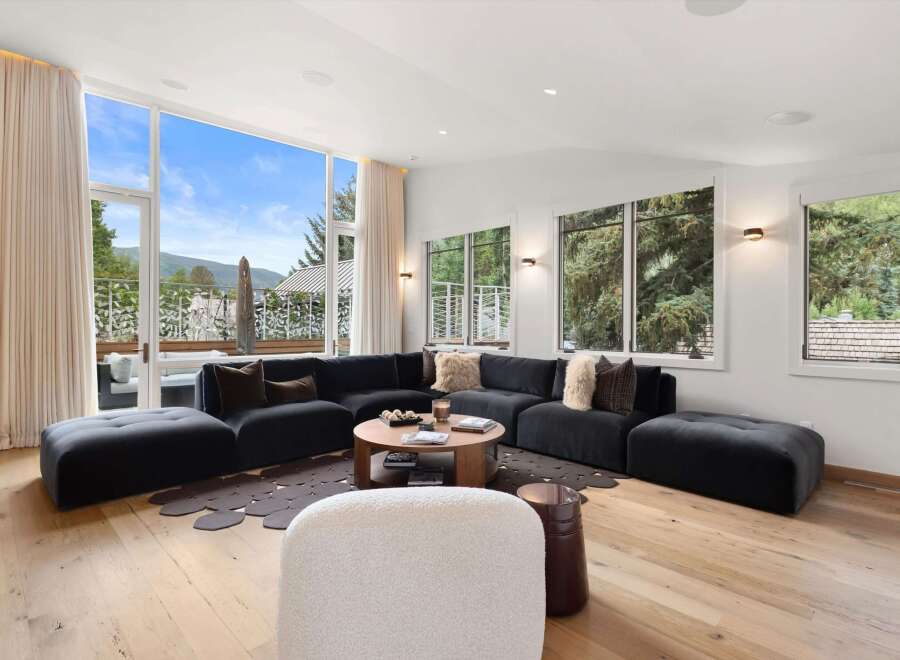 Experience breathtaking mountain views from this stunning living room, featuring a spacious sectional sofa and a modern coffee table.