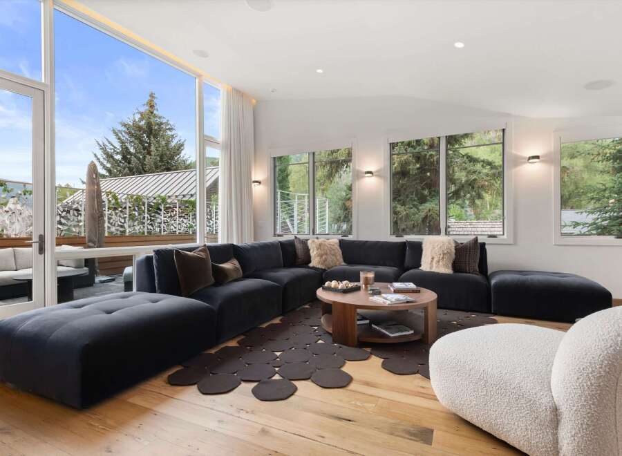 Experience modern luxury in this spacious living room, featuring a large sectional sofa and a stylish coffee table.