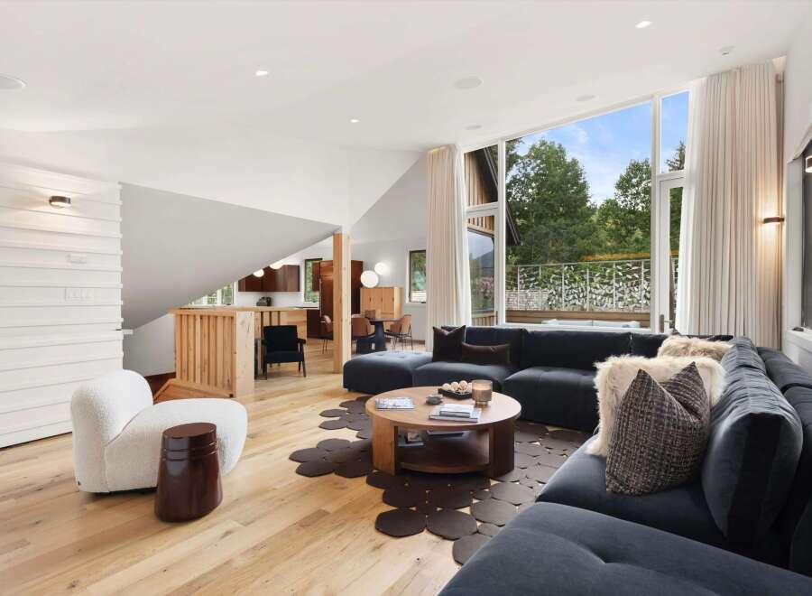 Experience modern living in this stunning open-concept living space, featuring a spacious sectional sofa and a unique circular coffee table.