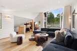 Experience modern living in this stunning open-concept living space, featuring a spacious sectional sofa and a unique circular coffee table.