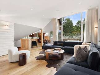 Experience modern living in this stunning open-concept living space, featuring a spacious sectional sofa and a unique circular coffee table.