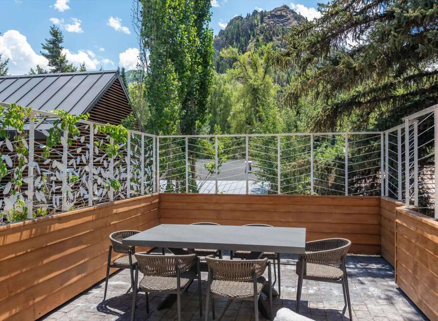 Enjoy al fresco dining on this spacious patio, complete with a modern dining set and comfortable seating.