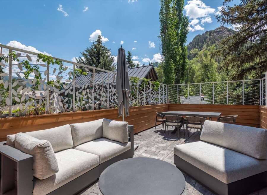 Enjoy breathtaking mountain views from this stunning outdoor living space, featuring a spacious patio with comfortable seating and a dining area.