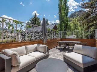 Enjoy breathtaking mountain views from this stunning outdoor living space, featuring a spacious patio with comfortable seating and a dining area.