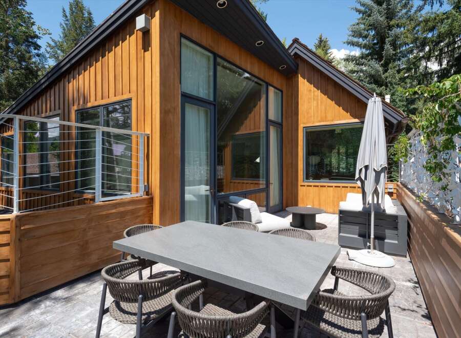 Enjoy outdoor living on this spacious patio featuring a modern dining set perfect for al fresco meals.
