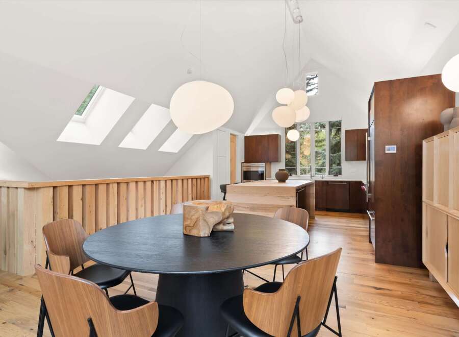Experience modern living in this stunning open-concept dining and kitchen area, bathed in natural light from multiple skylights.