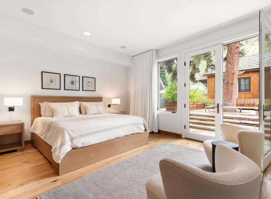 Experience luxurious comfort in this master bedroom, featuring a king-sized bed with plush bedding and a modern wooden headboard.