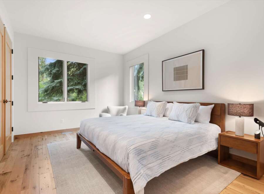 Experience tranquility in this serene bedroom, featuring a comfortable king-size bed adorned with crisp white linens and accent pillows.