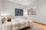 Experience comfort and style in this beautifully appointed bedroom, featuring a plush bed adorned with decorative pillows and a striped duvet.