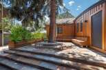 Experience seamless indoor-outdoor living with this stunning patio featuring natural stone paving and a built-in wooden bench.