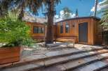 Experience outdoor living at its finest with this charming patio space, featuring natural stone steps and a built-in wooden bench perfect for enjoying the serene surroundings.