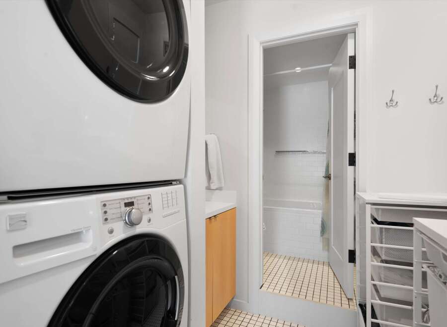 This laundry area features a stacked white washer and dryer for space efficiency.