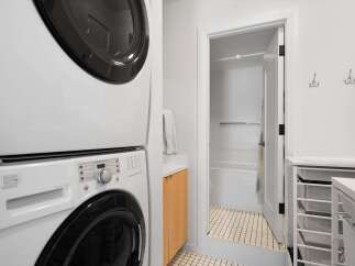 This laundry area features a stacked white washer and dryer for space efficiency.
