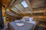 Experience rustic charm in this stunning bedroom featuring exposed wooden beams and a cozy ambiance.