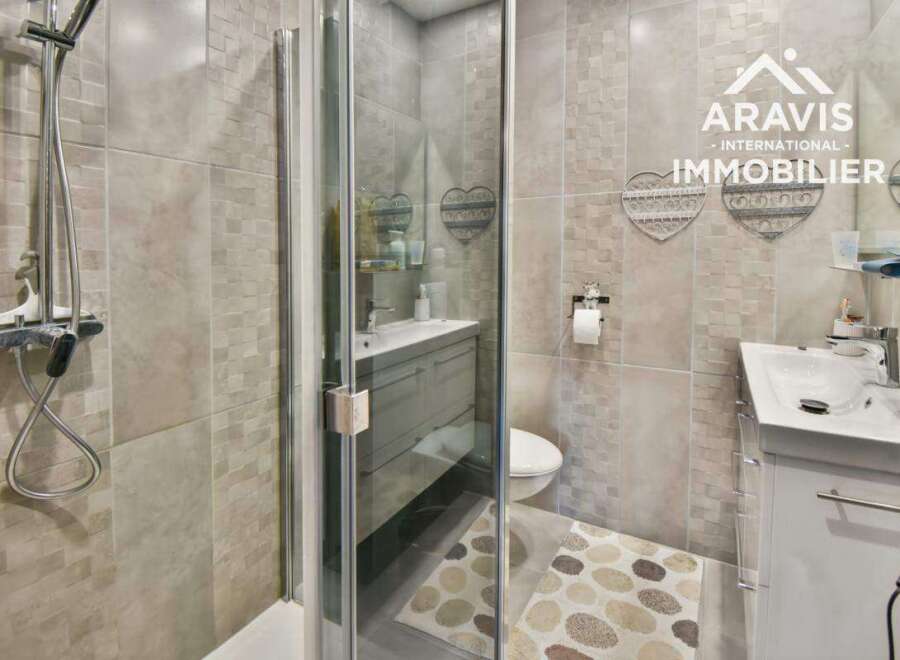 Step into this modern bathroom featuring a sleek shower enclosure and stylish vanity.