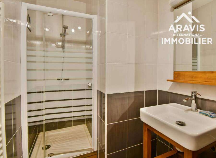 Discover this modern bathroom featuring a sleek glass shower enclosure and stylish tiling.