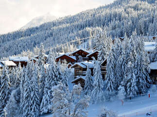 Nestled amidst a snow-covered mountain, this charming property offers a serene winter escape.