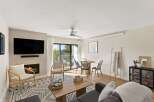 Step into modern comfort in this stunning living space, featuring a cozy fireplace and a sleek, mounted TV.