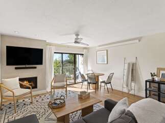 Step into modern comfort in this stunning living space, featuring a cozy fireplace and a sleek, mounted TV.