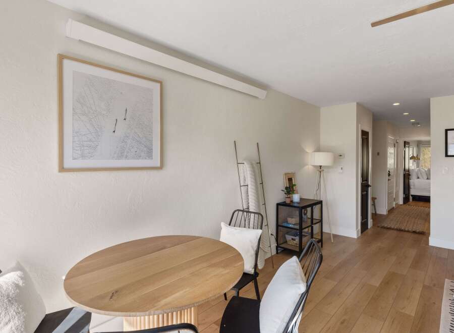 This inviting dining area features a stylish round wooden table, perfect for intimate gatherings.