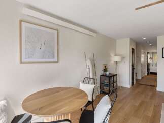 This inviting dining area features a stylish round wooden table, perfect for intimate gatherings.