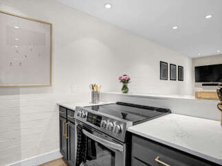 This modern kitchen boasts sleek countertops and stainless steel appliances, perfect for culinary enthusiasts.