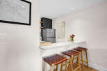 This stunning kitchen features a sleek breakfast bar, perfect for casual dining or entertaining.