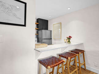 This stunning kitchen features a sleek breakfast bar, perfect for casual dining or entertaining.