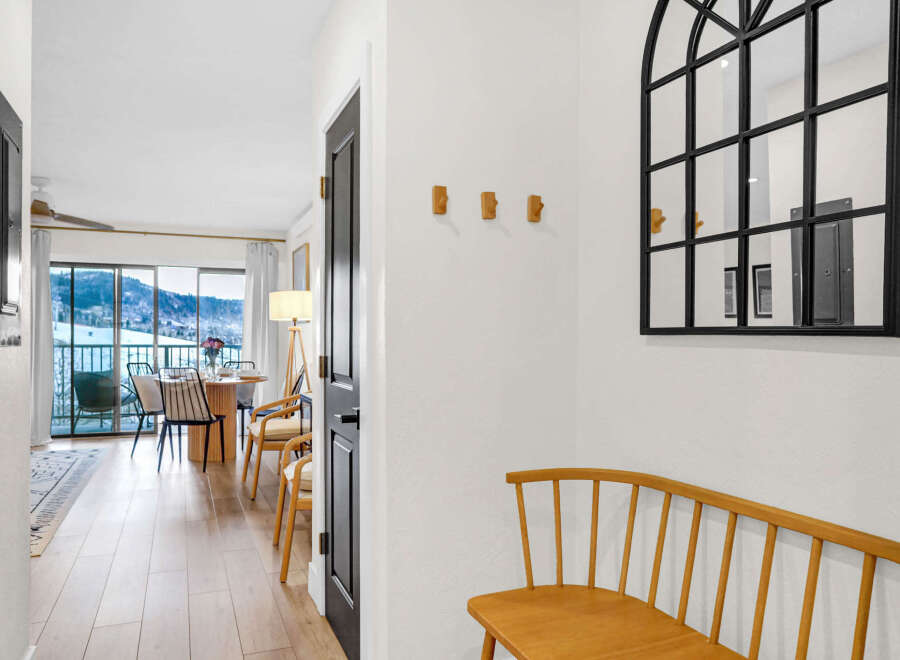 Step into this inviting entryway, showcasing a stylish arched mirror and a charming wooden bench.