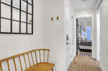 Step into this inviting entryway, showcasing a stylish bench and a decorative mirror.