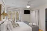 This inviting bedroom features a comfortable bed with plush pillows and a stylish gray throw.