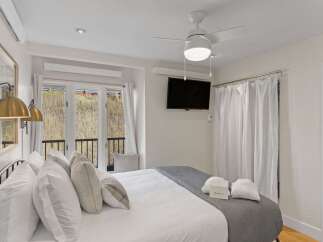 This inviting bedroom features a comfortable bed with plush pillows and a stylish gray throw.