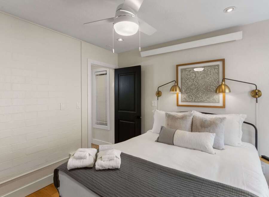 Step into this inviting bedroom, featuring a comfortable bed adorned with plush pillows and a stylish gray throw.