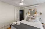 Step into this inviting bedroom, featuring a comfortable bed adorned with plush pillows and a stylish gray throw.