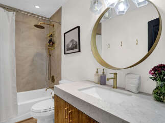 Step into luxury with this stunning bathroom! Featuring a sleek marble countertop, gold fixtures, and a modern design, this space offers both style and functionality.