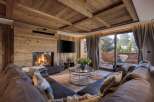 Experience the epitome of luxury living in this stunning chalet, featuring a cozy fireplace and a spacious, comfortable sofa.