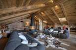 Experience luxury living in this stunning chalet, featuring a cozy living room with a unique fireplace and plush seating.