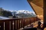 Enjoy breathtaking mountain views from this charming chalet balcony.