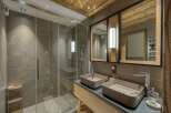 Step into luxury with this stunning bathroom, featuring a sleek glass shower and modern double sinks.