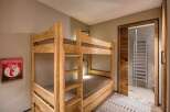 This cozy bedroom features custom-built wooden bunk beds, perfect for accommodating guests or family members.