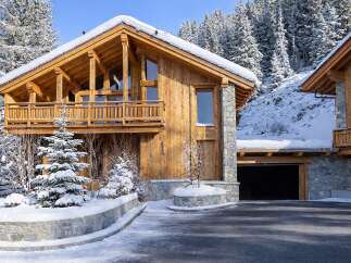 This stunning wooden chalet, nestled in a snowy landscape, offers a luxurious retreat.