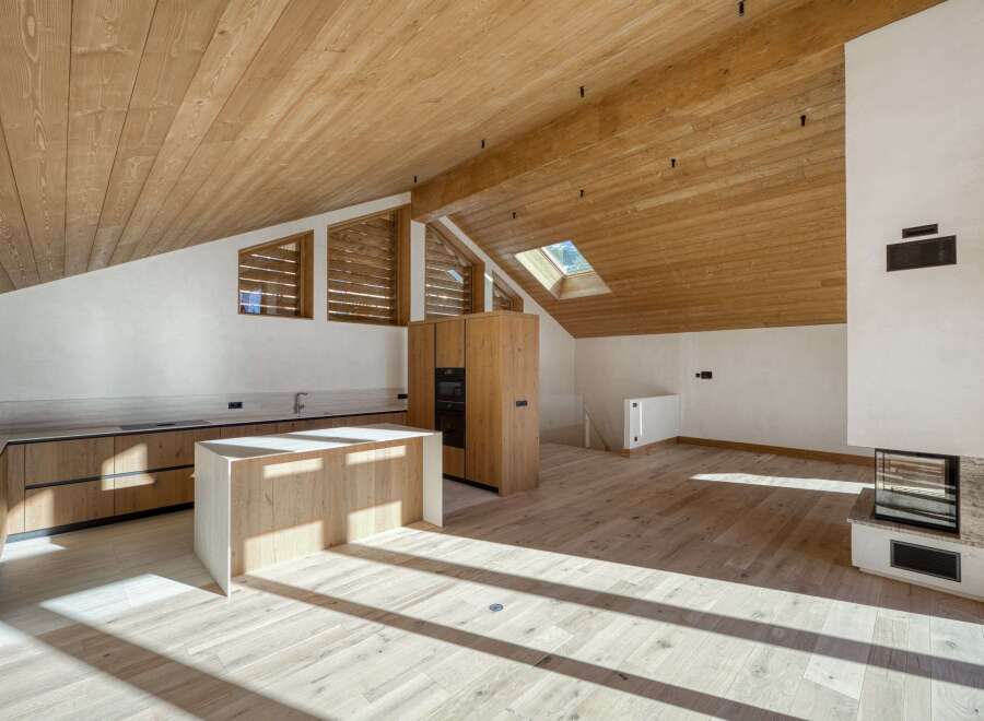 This stunning property boasts a modern kitchen with sleek wooden cabinetry and a spacious island, perfect for culinary enthusiasts.