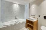 This modern bathroom features a sleek design with a soaking tub and a stylish vanity.